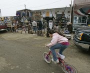 A child pedals her bike in front of shops in the Puerto Nuevo area of Rosarito, Mexico. Recent violence has contributed to a dramatic drop in tourist business in the area, which is on the Baja California peninsula, south of San Diego.