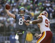 Seattle quarterback Matt Hasselbeck (8) unleashes a pass under pressure from Washington's Phillip Daniels. The Seahawks defeated the Redskins, 35-14, on Saturday in Seattle.