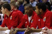 Kansas University's Mario Chalmers, center, sits on the bench between Tyrel Reed, left, and Jeremy Case, right, as the Jayhawks play Loyola. Chalmers rested during the Jayhawks' victory Tuesday but expects to play Saturday at Nebraska.