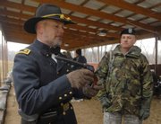 Kendall Gott, left, senior historian at Fort Leavenworth, shows an 1873 Colt pistol to Maj. Brett Clark who was among a group of soldiers and civilians from across the country taking a two-week course at Forth Leavenworth about how to teach military history. Gott demonstrated how to use the gun on Thursday at a Fort Leavenworth firing range.