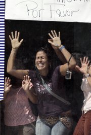 Hostages held by gunmen inside a bank show their despair in Altagracia de Orituco, Venezuela. Gunmen held more than 50 people hostage for more than 24 hours during a standoff with police that began with a botched robbery Monday. The sign in Spanish reads "Please."