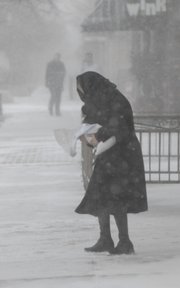Tuesday's sudden drop in temperature -- 20 degrees in 2 hours -- was all it took to create havoc in downtown Lawrence. Jessica Irving, It's About Time employee, tried to help melt some of the snow and ice that was forming on the sidewalks.