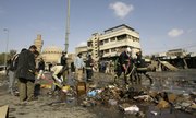 Iraqis participate in cleanup at the site of a suicide bombing at a popular pet market Friday in central Baghdad. Two female suicide bomber killed at least 91 people, police said, the deadliest bombing to strike the capital since 30,000 more U.S. troops flooded into central Iraq last spring.