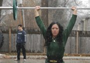 Janice Boline carries weights through the falling snow during a strongman workout outside the Next Level gym, 644 Locust St. Trainers and Next Level clients took part in the functional-movement exercise during a Jan. 16 dusting. In addition to the overhead barbell, participants pulled a tire tied to a belt around their waists.