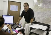 Thomas Blanchard, a broker and owner of REO Asset Services, which sells bank-owned properties, talks to an employee in his office last week in Las Vegas. Blanchard estimates that 60 percent of properties on the market there are the result of foreclosures.