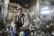 Abbas Hussein sits in the ruins of his shop Friday in central Baghdad. A bomb planted under a horse pulled cart exploded, killing at least three and destroying some shops