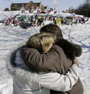 Mourners Doris Kalinoski, left, and Addie Meiser, of Sycamore, Ill., hug Saturday near a memorial to the five students who were killed during the Valentine's Day shooting at Northern Illinois University in DeKalb, Ill.