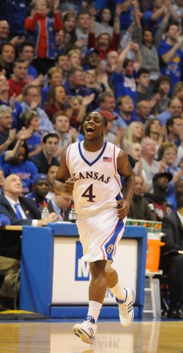 Kansas University guard Sherron Collins trots back on defense with a wide smile after drilling a three-pointer in the Jayhawks' 88-74 victory over Kansas State. Collins hit three of seven treys - and KU 11 of 23 - in the victory Saturday in Allen Fieldhouse.
