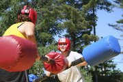 Alexandra Hagemann, 19, right, jousts with an unidentified participant on an inflatable jousting arena last August at the alumni field at a Wellspring New York camp at Paul Smiths College, Paul Smiths, N.Y.