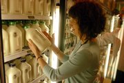 General Manager Jeanie Wells looks a the labeling on the bottles of milk sold at the Community Mercantile Co-op, 901 Iowa, on Wednesday. The Kansas Legislature is pitting large dairies against smaller counterparts, and it's all about labels on milk containers.