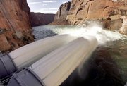 Water flows from two jet tubes Wednesday at Glen Canyon Dam in Page, Ariz. The Department of Interior is experimenting with high flows of water from the dam to help, in part, rebuild beaches along the Colorado River that runs through the Grand Canyon.