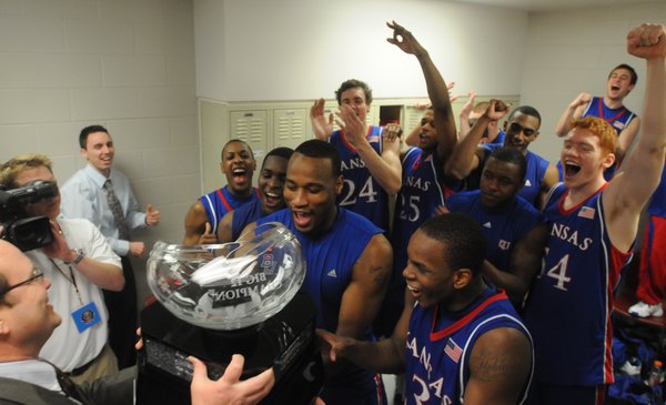The Kansas University's men's basketball team receives the Big 12 Conference championship trophy from league commissioner Dan Beebe, left. KU's 72-55 victory over Texas A&M on Saturday in College Station, Texas, gave the Jayhawks at least a share of their fourth league crown in four seasons.