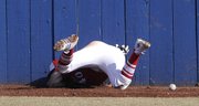 Kansas center fielder Nick Faunce nails the wall and looses handle on the baseball against Tabor on Tuesday at Hoglund Ballpark.