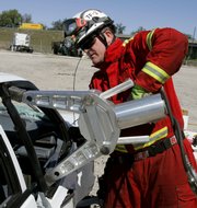 A Hillsborough County firefighter opens up a car&squot;s door during a "Jaws of Life" demonstration recently in Tampa, Fla. Today&squot;s cars save lives by cocooning motorists in reinforced alloys, impact-absorbing crumple zones and as many as a dozen air bags. But rescue officials and experts from around the United States say the new technology is also hindering extrication of injured people.