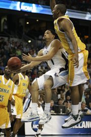 Villanova's Scottie Reynolds, center, flies by the Siena defense for a layup. Reynolds led the Wildcats with 25 points in their 84-72 second-round victory Sunday in Tampa, Fla.