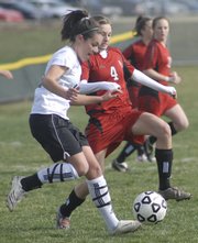 Free State midfielder Hannah Carlson, left, and Lawrence High's Stef Stuever fight for a possession. The Firebirds beat the Lions, 1-0, Tuesday at FSHS.