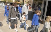 Students from New York School were paired Monday with athletes from Kansas University for LPS On the Move, a program to promote the importance of physical activity. Fourth-grader Kai Blosser, 10, center, was among the students joining KU men's basketball players Conner Teahan, left, and Cole Aldrich for a short stroll from the school at 936 N.Y. to Massachusetts Street.