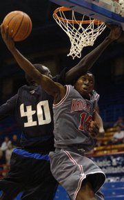 K.C. Pump N Run's Justin Clark, right, draws a foul against Cheyenne Pump N Run Elite. The teams were part of the Jayhawk Invitational that opened Friday at Allen Fieldhouse.