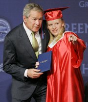 President Bush hands a high school diploma to Kasha Marie Charlton on Sunday during Greensburg High School's graduation.