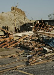 A home is reduced to rubble in the shadow of a chat, or mine tailings, pile in Picher, Okla. A tornado on Saturday ripped through the town, which was already largely abandoned because of pollution problems. An estimated 800 people still lived there.