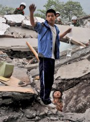 A student helps his schoolmate stranded in the ruins of a high school in Beichuan county, in southwest China's Sichuan Province. The death toll from a powerful earthquake climbed today to at least 10,000 as rescue efforts entered a second day.