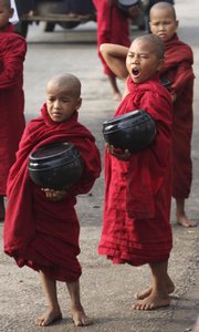 Young monks wait for free transportation as they head out to collect donations Friday at a bus stop on the outskirts of Yangon, Myanmar.
