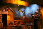 A member of the media tries the shooting gallery during a media preview of the National Museum of Crime and Punishment in Washington. The museum opens to the public on Friday.