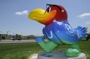 The "Peace, Love and Daisy Hill forever" Jayhawk by Susan Younger and Valerie Spicher has been repaired, repainted and is back to strutting its feathers in front of the Douglas County Bank at 31st and Iowa. The Jayhawk, which was placed at its new spot Tuesday, had suffered significant vandalism when perched at Sixth Street and Folks Road, and its paint had faded significantly. The new paint is auto paint.