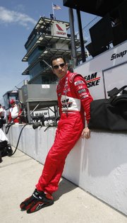 IRL driver Helio Castroneves watches practice from the pits in this file photo from May 17. The Brazilian hopes to become the fourth member of the elite group of drivers who have won three Indy 500s in a single decade.