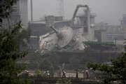 Chinese railway workers walk along the damaged train tracks Friday in front of a destroyed chemical plant outside the town of Hongbai of Shifang county, in China's southwest Sichuan province. The May 12 quake killed more than 55,000, and more than 5 million people in Sichuan province remain homeless.