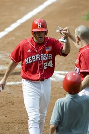 Nebraska's Bryce Nimmo accepts congratulations after scoring against Kansas State. The Cornhuskers won, 5-2, in the Big 12 baseball tournament Friday in Oklahoma City.
