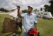 Renaissance Village trailer park resident Derrick Williams, right, and his friend Larry Jackson haul items to the Dumpster Saturday in Baker, La., as Williams prepares to move from the FEMA site to a nearby apartment. FEMA is trying to close its last six trailer parks in Louisiana by today.