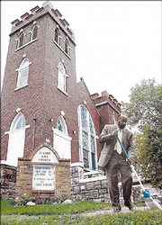 The Rev. Verdell Taylor sweeps the sidewalk in front of St. Luke African Methodist Episcopal Church, 900 N.Y.