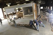 KU architectural students in Studio 804 push a section of their sustainable building out of their warehouse at Farmland Industries before it was shipped to Greensburg in March. The U.S. Green Building Council has certified the building at LEED Platinum for being environmentally friendly.
