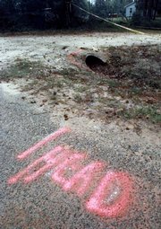 Spray paint marks the spot where officials found the head of James Byrd, a 49-year-old black man, along Huff Creek Road near Jasper, Texas, in this June 9, 1998, file photo. Byrd was tied to a truck and dragged to his death along the rural East Texas road in the early morning on June 7, 1998.