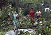 Residents of Yangon, Myanmar, make their way through fallen trees, following cyclone Nargis, in this May 4 file photo. Before the cyclone struck, Yagon was known for its scenic, tree-lined streets.