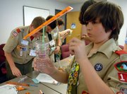 Boy Scout Matthew Murrow makes a wind vane during a Weather Merit Badge Day workshop at the National Oceanic and Atmospheric Administration on Friday at the National Weather Service headquarters in Silver Springs, Md.