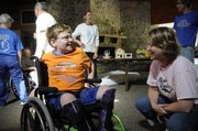 Luke Bruner, 9, Lawrence, visits with Angela Hills, director for the Kansas City area Muscular Dystrophy Association's one-week summer cap at Tall Oaks near Linwood. The week-long camp, solely for kids with muscle-wasting diseases, has about 75 participants, each paired with a counselor for one-on-one attention throughout the week. .