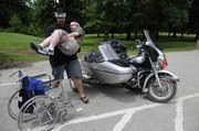 Camp counselor John Cardarella, of Independence, Mo., lifts camper George Li, 15, Overland Park, from his wheelchair to the sidecar of a motorcycle for a ride. The pair were wearing matching headbands that they made in a crafts session at the MDA summer camp, which was last week at the Tall Oaks Conference Center near Linwood.