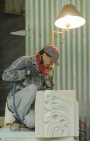 Laura Ramberg works on a 900-pound block of cottonwood limestone in her rural Lawrence shop. The sculpted stone is one of three pieces that Ramberg is completing for the Douglas County Courthouse. Ramberg and Oskaloosa stone carver Keith Middlemas are both sculpting new pieces to replace deteriorated stone sections.