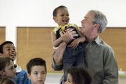 President Bush lifts Dominic Bernier, 3, during a visit to the Red Cross shelter for flood victims Thursday at the Johnson County Fairgrounds in Iowa City, Iowa.