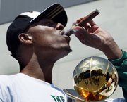 Boston's Paul Pierce puffs on a cigar while holding the championship series MVP trophy during a victory parade Thursday in Boston.