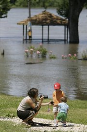 Tonya Sheppard photographs her two sons Will and Brady on Sunday in a park near the floodwaters of the Mississippi River in Louisiana, Mo.