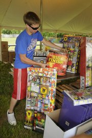 Ryan Hutton helps set up a fireworks stand Monday south of Lawrence on U.S. Highway 59. Many area fireworks vendors have high expectations for Independence Day sales. This year's holiday falls on a Friday, and rain is not in the current forecast.