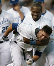 Kansas City's David DeJesus, front, is congratulated by Jose Guillen after DeJesus hit a two-run, walkoff home run in the ninth inning. The home run gave the Royals a 5-4 victory against Seattle on Saturday in Kansas City, Mo.