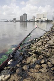 Booms are in place to contain a fuel oil spill Friday in the Mississippi River at the Port of New Orleans. Officials are worried that the spill will affect the fragile wetlands downstream.