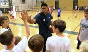 Wayne Simien high-fives his campers after running through the importance of working hard off the ball on defense. Simien ran the first session of his "Called to Greatness" basketball camp on Tuesday at Free State High.