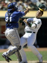 Kansas City catcher Miguel Olivo, left, tags out Oakland's Carlos Gonzalez in the sixth inning Wednesday in Oakland, Calif. Gonzalez attempted to score on a hit by Jack Cust.