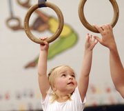 Elena Heatwole, 3, reaches to grasp a set of rings during a children's class at the East Lawrence Parks and Recreation Center, 1245 E. 15th St.