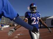 KU safety Darrell Stuckey high-fives a fan in this Nov. 17, 2007, file photo of pregame warmups before Kansas faced Iowa State at Memorial Stadium.